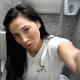 An attractive brunette woman records herself shitting into a toilet in a public restroom stall. Pooping sounds are fully audible. Presented in 720P HD video.
